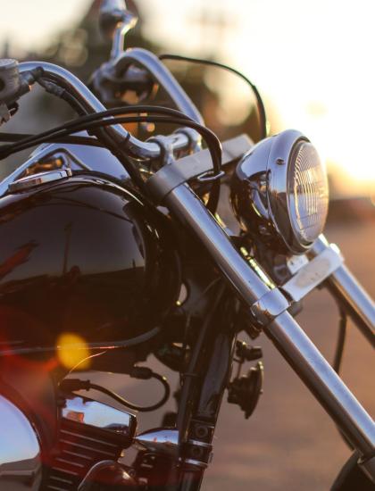 Motocicletta cromata al tramonto su strada aperta.