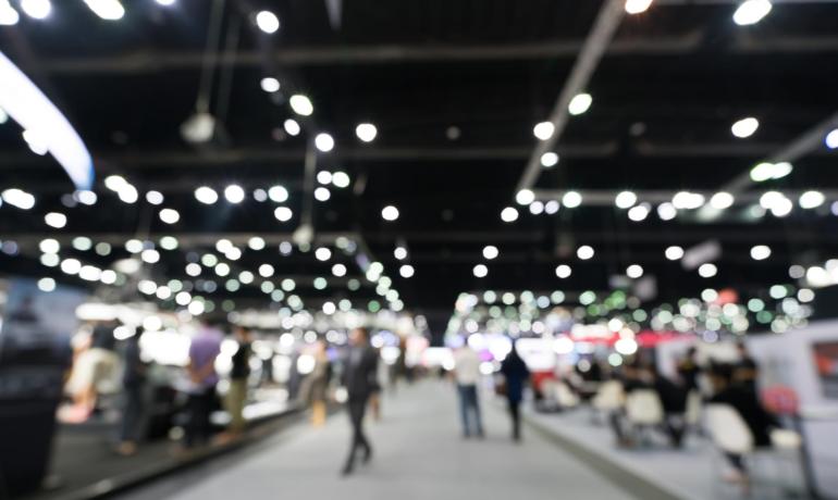 Fiera con persone e luci sfocate, ambiente vivace.