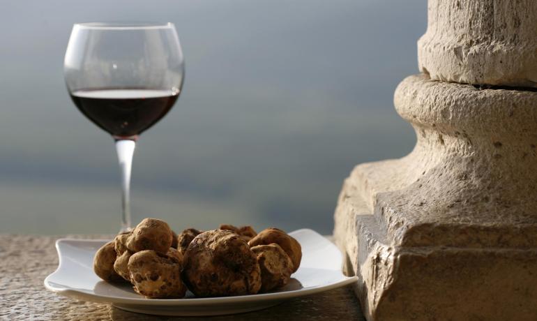 Bicchiere di vino e tartufi su un piatto di pietra.